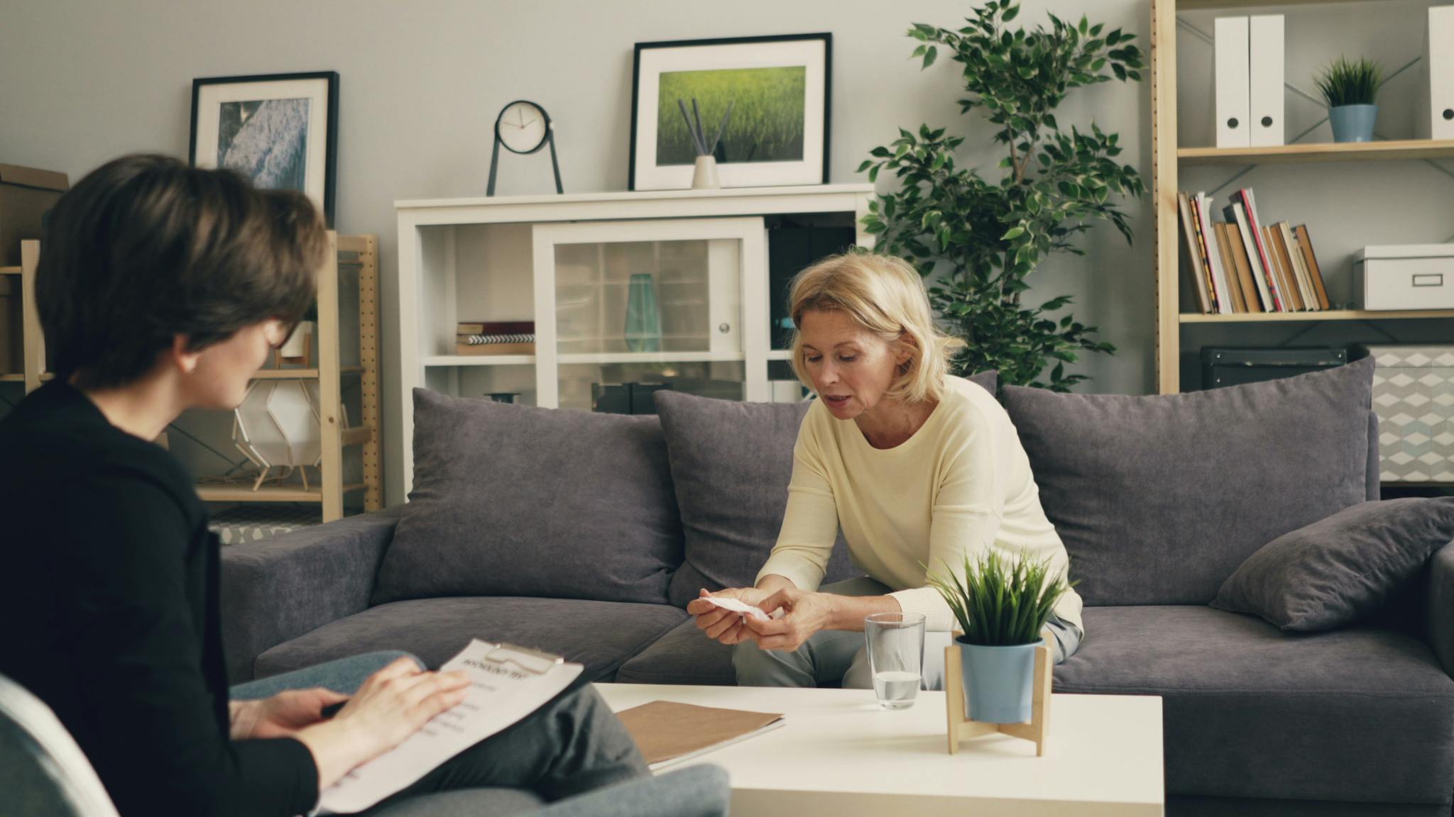 A professional therapy session with a therapist and patient in a modern living room setting.